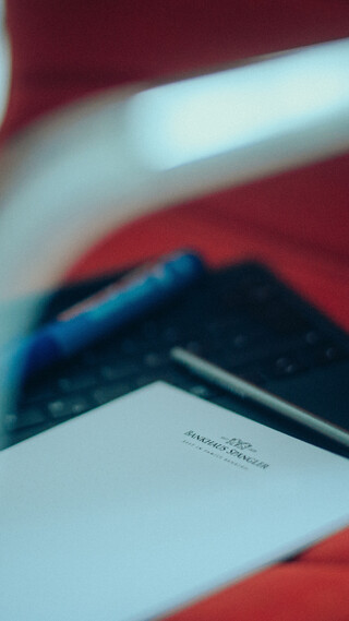 Eine Tastatur und ein Block liegen auf einem roten Sessel.