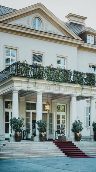 Eingangsbereich eines historischen Gebäudes mit rotem Teppich.