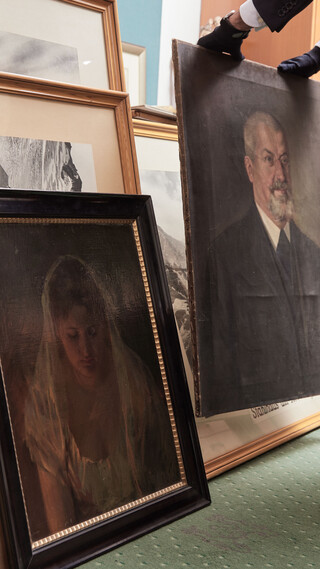 Mann steht vor alten Gemälden