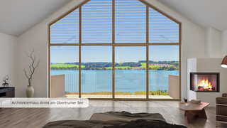 Zimmer mit raumhohen Fenstern unter abgeschrägtem Dach mit Blick auf einen See.