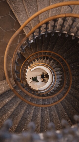 n der Mitte einer runden Steintreppe sitzt eine Frau und liest Zeitung.