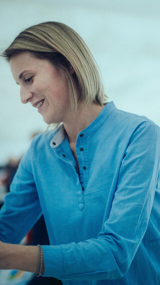 Eine lächelnde Dame beschreibt ein Flipchart.