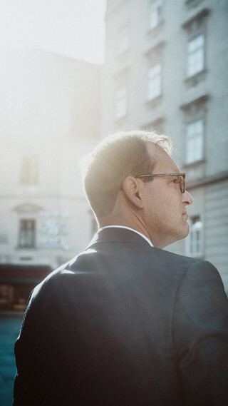 Ein Herr in Geschäftskleidung blickt in die Ferne.