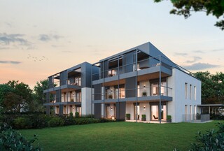 Ein modernes Mehrfamilienhaus mit Garten in der Abenddämmerung.