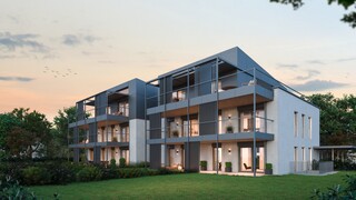 Ein modernes Mehrfamilienhaus mit Garten in der Abenddämmerung.