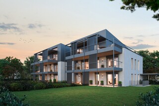 Ein modernes Mehrfamilienhaus mit Garten in der Abenddämmerung.