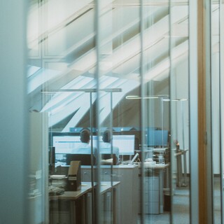 In einem Raum sind viele Tische und Computer aufgestellt. 