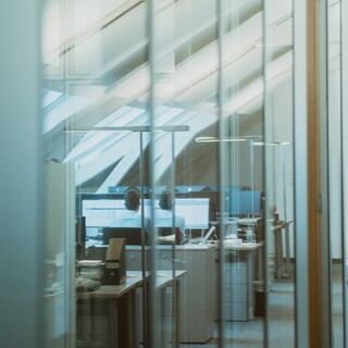 In einem Raum sind viele Tische und Computer aufgestellt. 