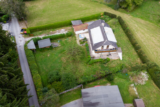 Älteres Einfamilienhaus mit Garten in grüner Landschaft aus der Vogelperspektive.