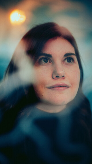 Eine lächelnde Dame blickt in die Ferne.