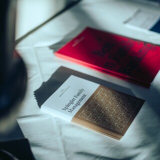 Informationsbroschüren liegen auf einem Tisch mit weißem Tuch.